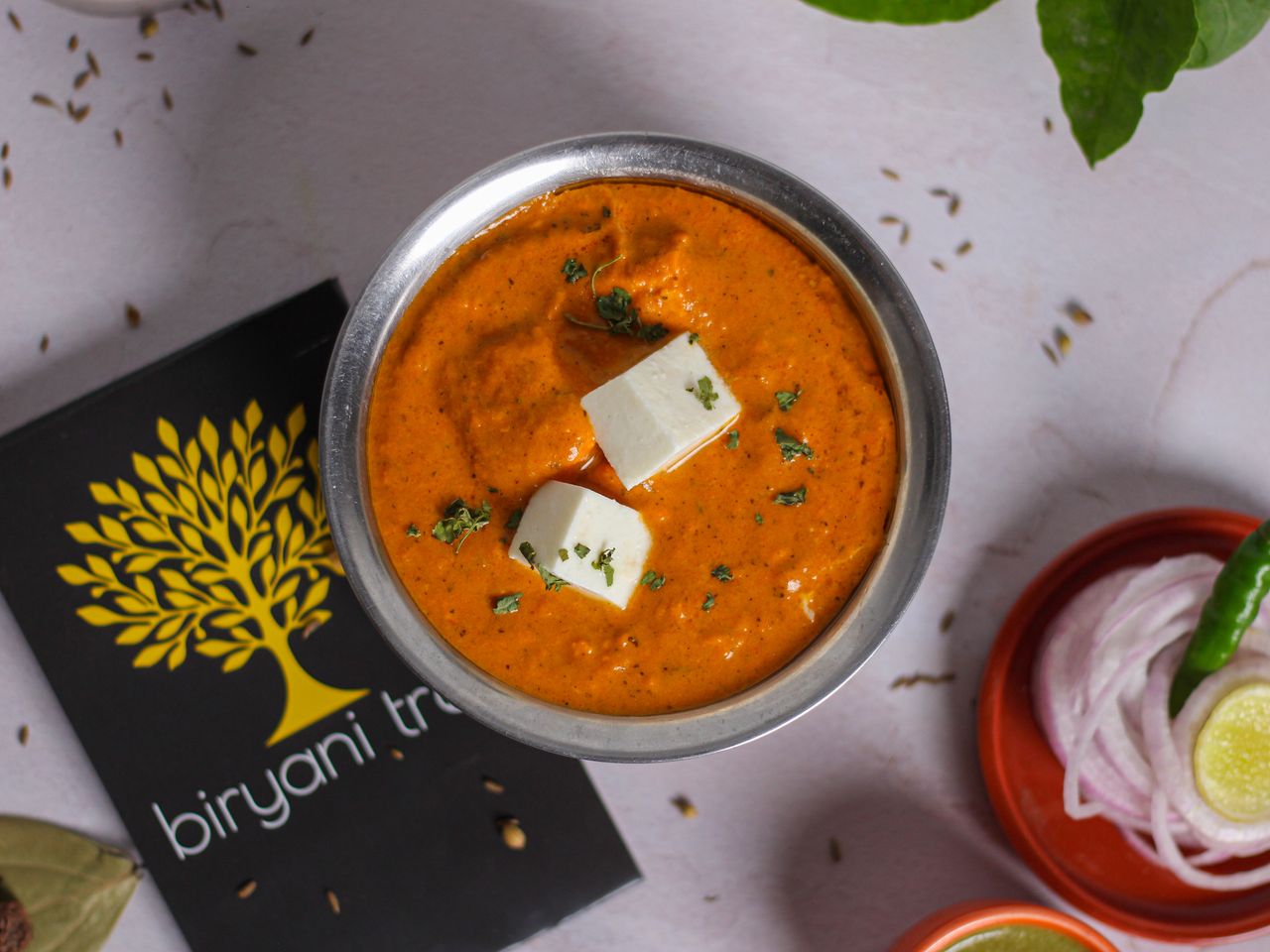 A mouth-watering overhead view of paneer makhani with creamy texture, garnished with herbs.